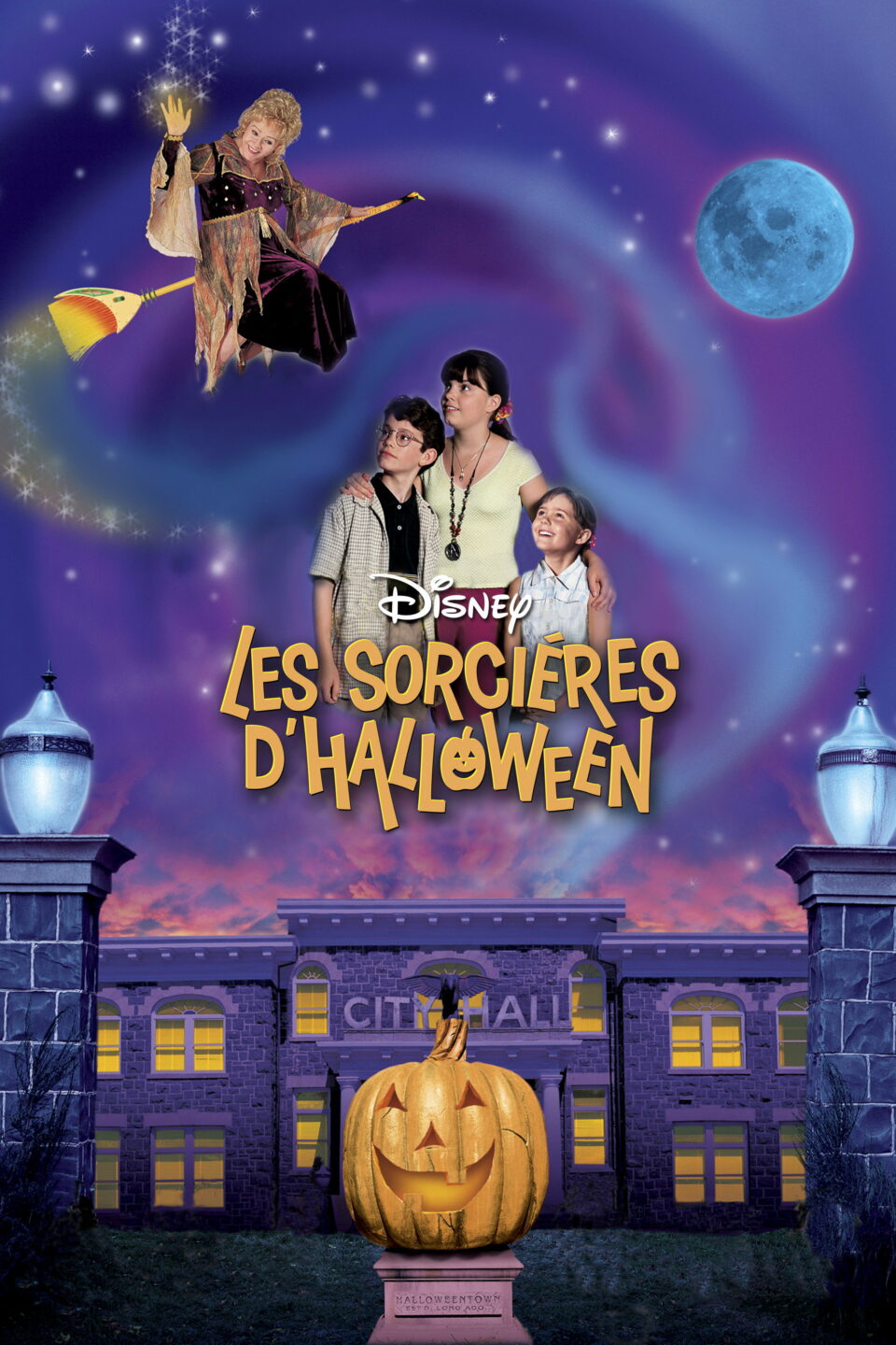 Affiche française des Sorcières d’Halloween (Halloweentown) : Marnie, ses frère et sœur et Agatha sur son balai devant la mairie