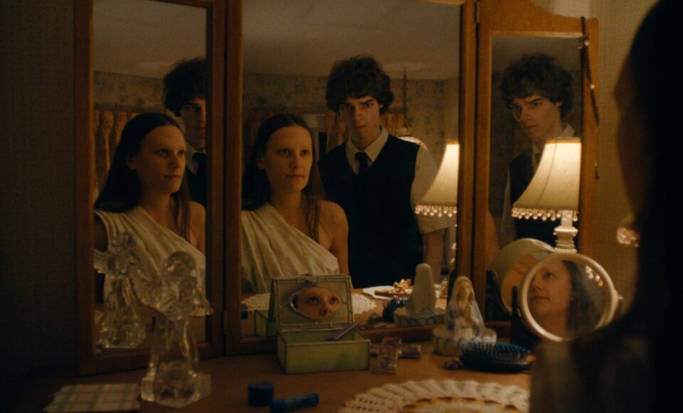 Image officielle de la série Netflix The Body montrant des adolescents réunis autour d’une coiffeuse à miroirs triptyque dans une chambre aux lumières tamisées